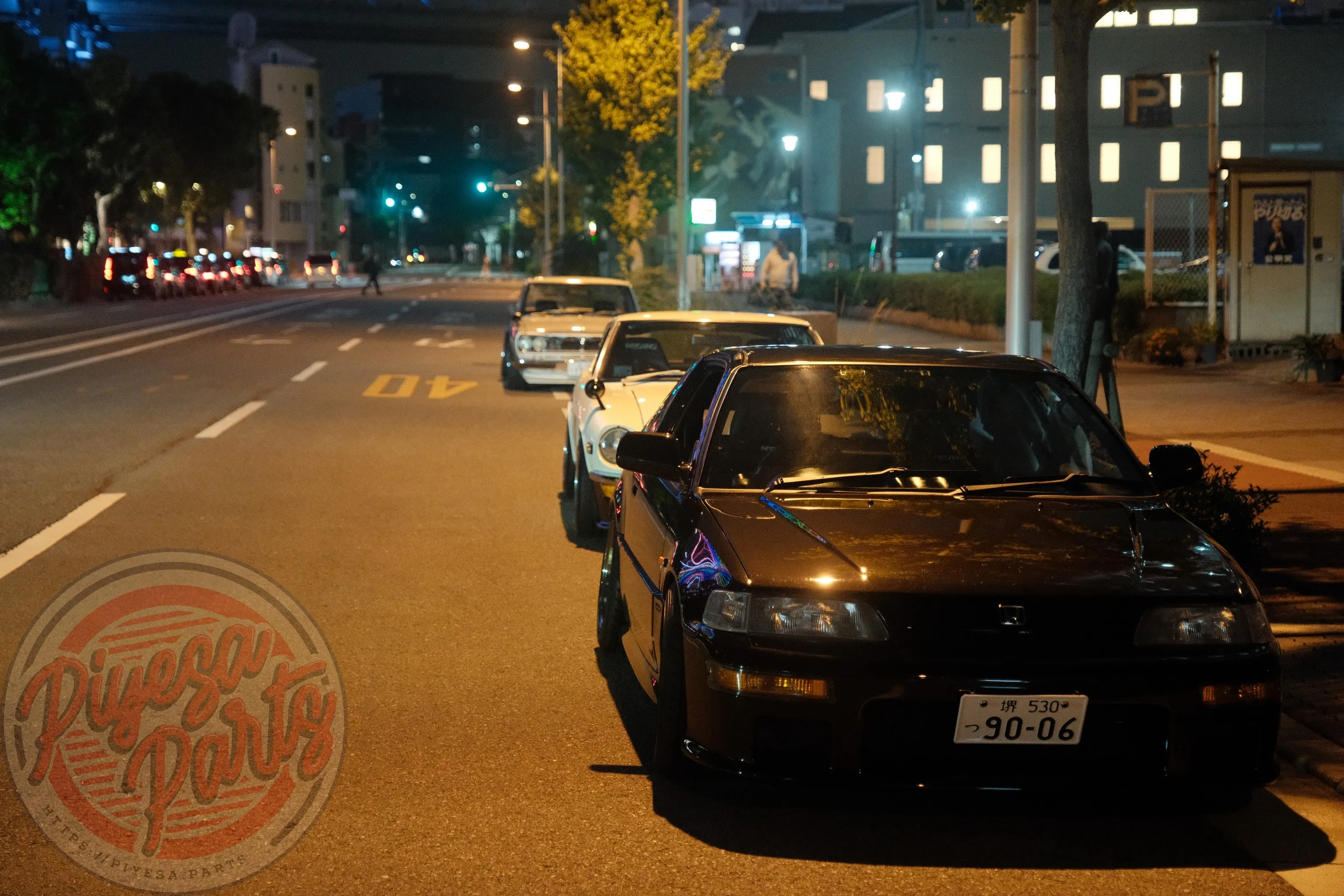 Three classic Japanese cars — Nissan Fairlady Z, Nissan Skyline Hakosuka, and Honda CRX EF8 parked near Tempozan Ferris Wheel in Osaka.